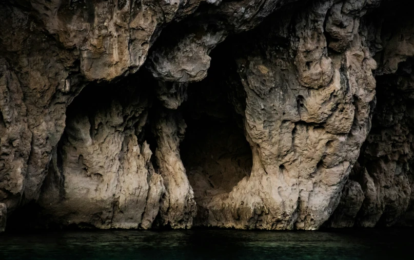 an unusual looking, rocky cave by the water