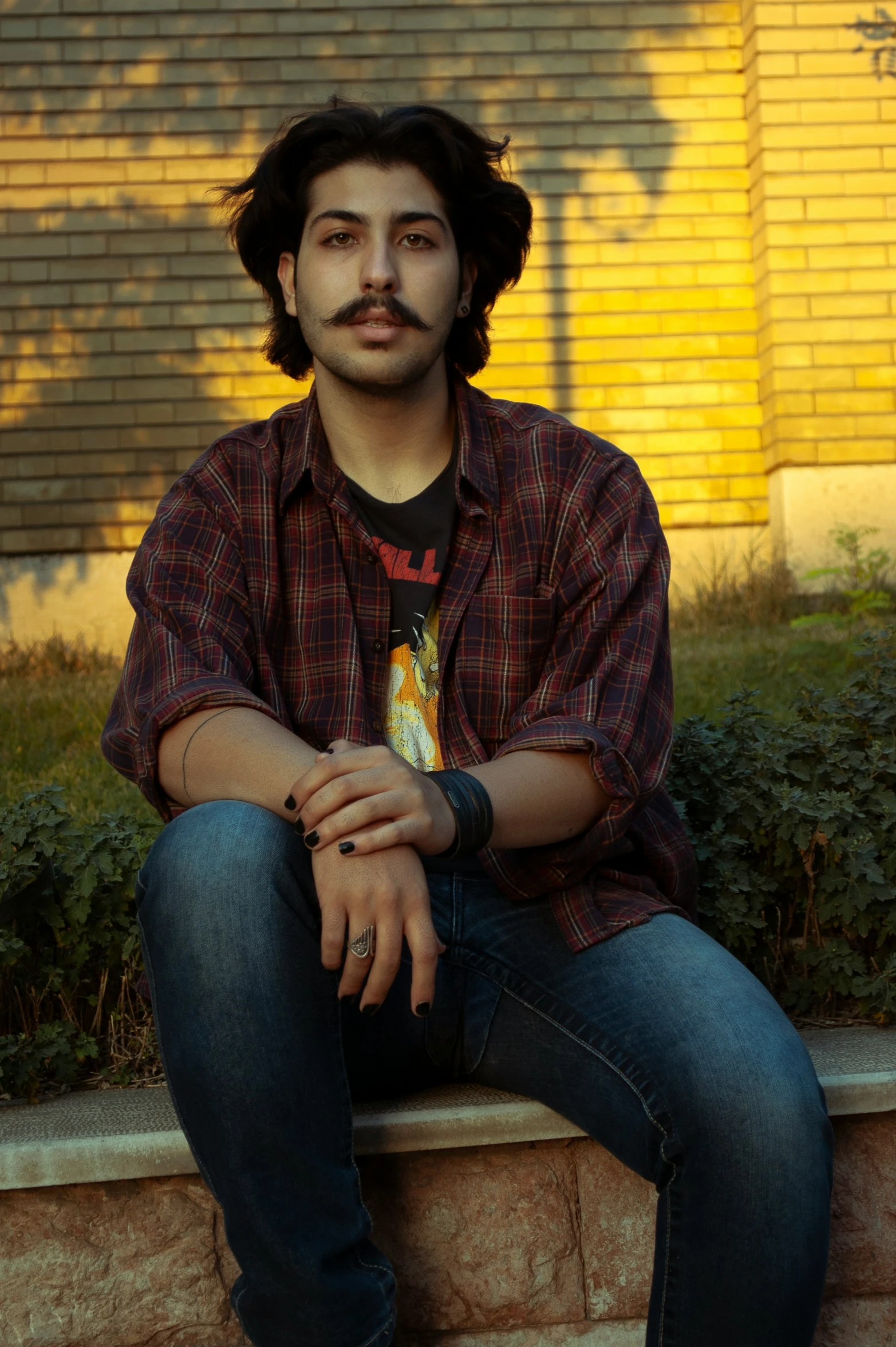 a man sitting on a wall in front of a building