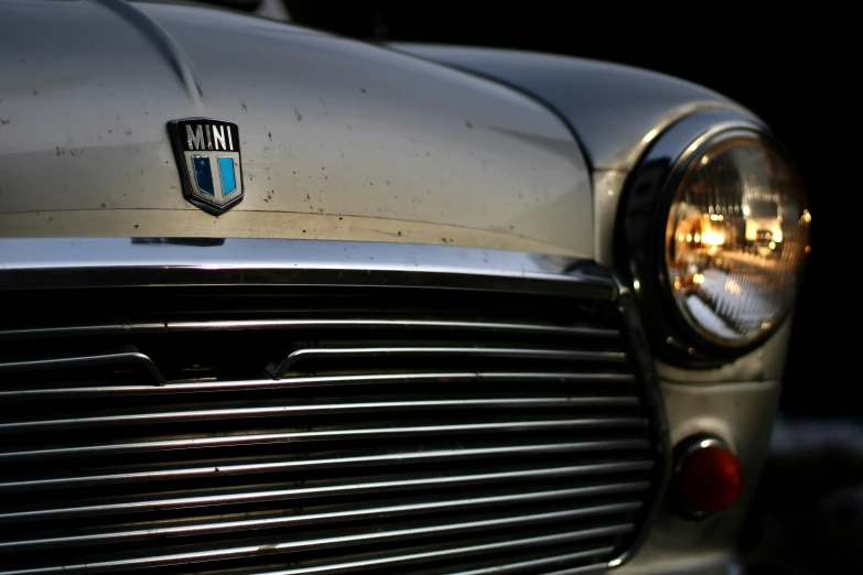 the front end of an old classic car with a badge