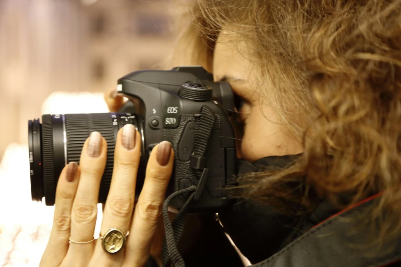 a close up of a person holding a camera with a ring