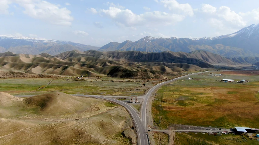 an aerial view of a road surrounded by mountains