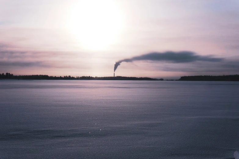 a large body of water in front of the sun