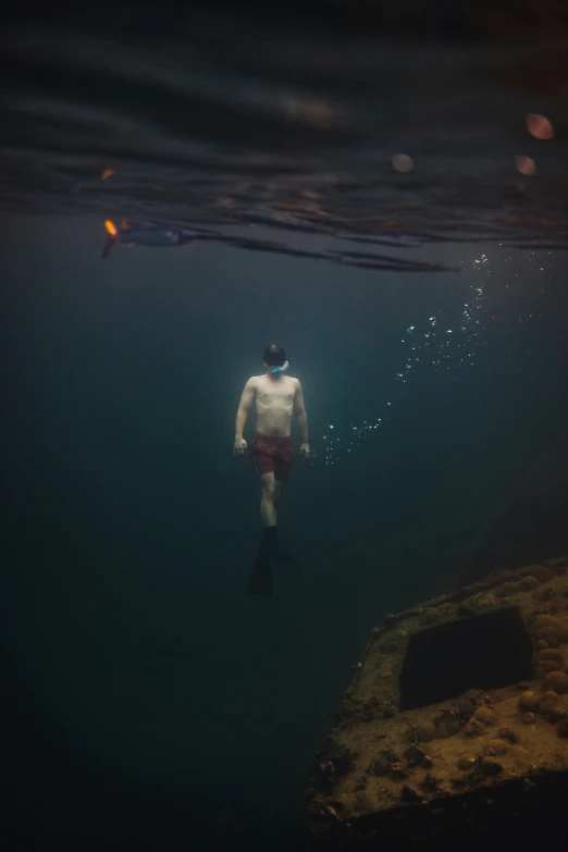 a man swimming in the ocean wearing a white shirt