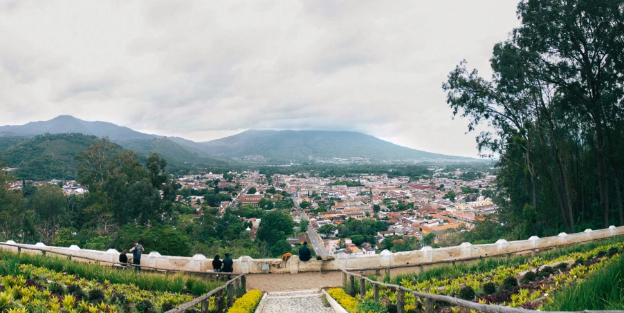 people walk up a path towards the city of medanon