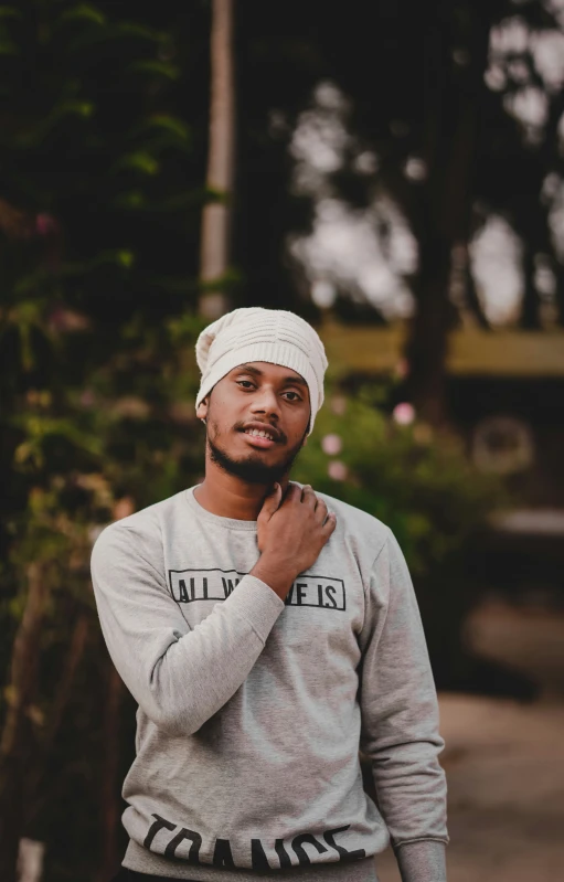 a man in a gray shirt is posing for a picture