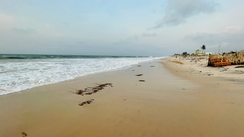 a sandy beach with the ocean and a sign that says it's not okay to go