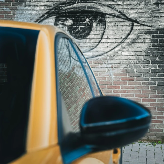 a car is parked in front of a brick wall