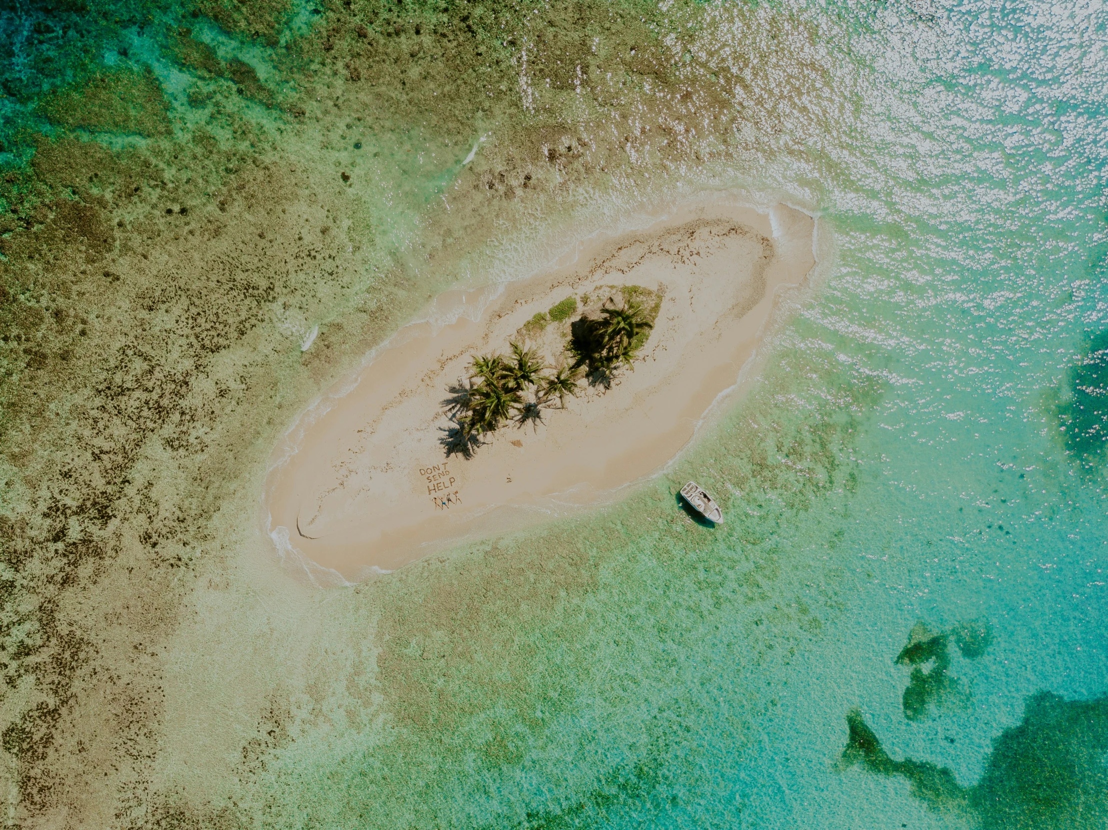 a sandy island sits in the middle of blue water