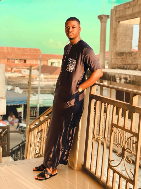 a man standing on top of a metal fence