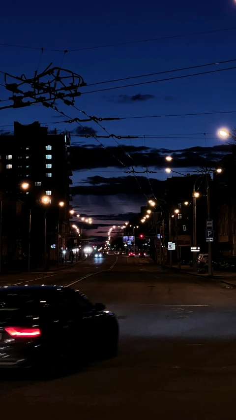 a dark street with lots of cars parked along it