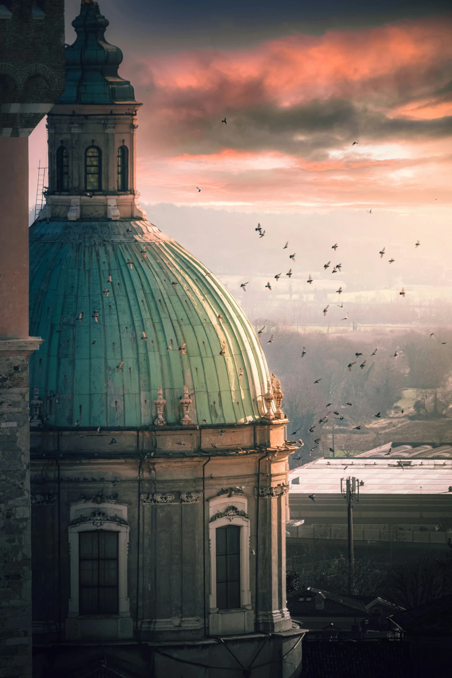 a view from a large tower at sunset of a sunset and birds flying by