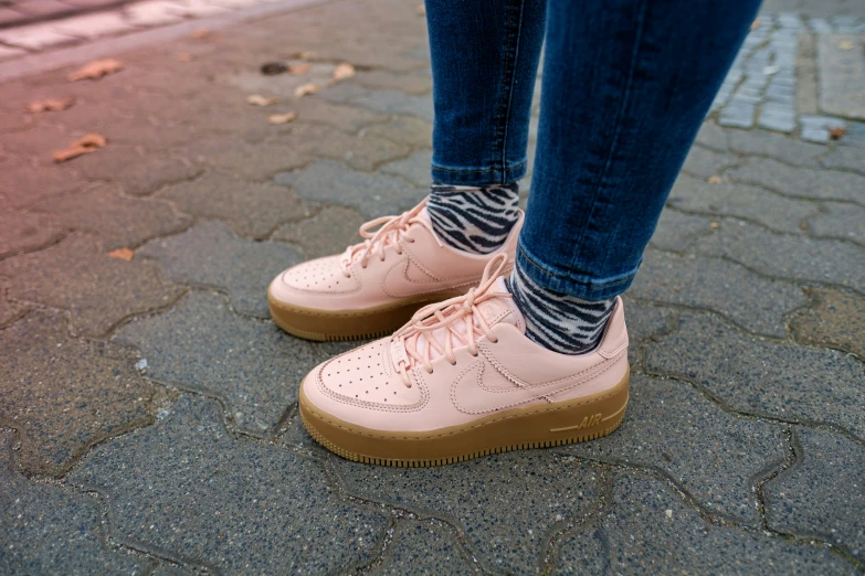 a women's pink shoe is on the pavement