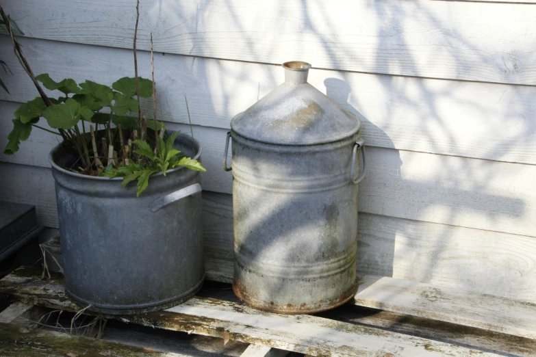 two galvanine buckets sitting on an outside porch