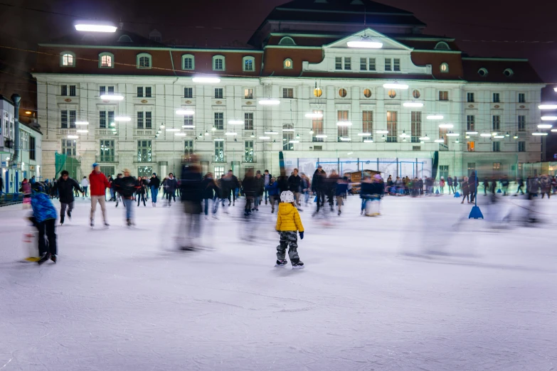 several people skating on ice rink in front of a large building