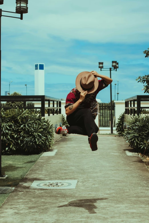 a man with a hat jumping in the air