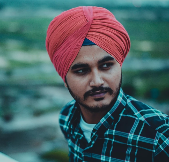 a man wearing a red turban standing in the city