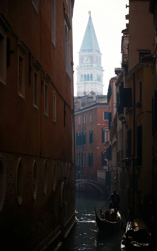 a boat traveling down a river with a tower behind it