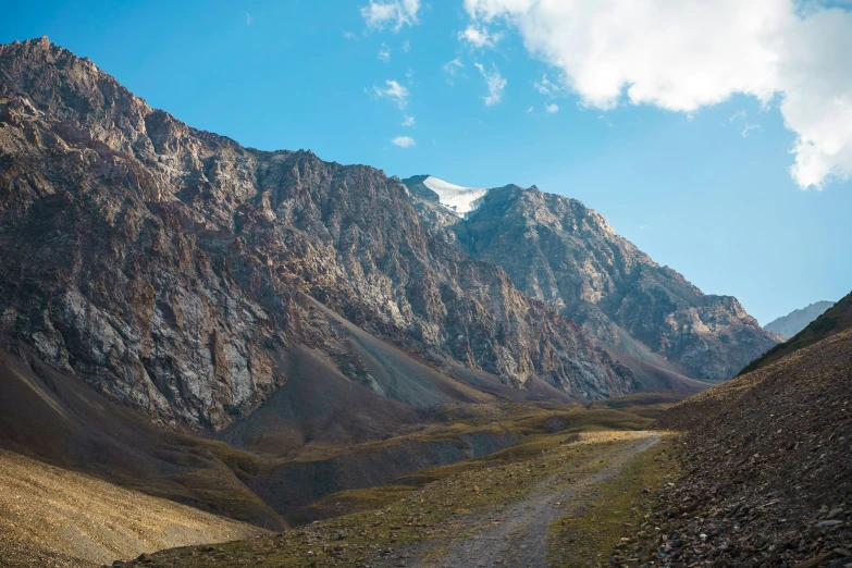 the road is near some mountains that look like they have snow on them