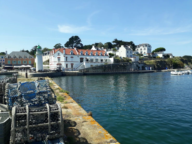 a waterfront with boats parked along it and houses in the background