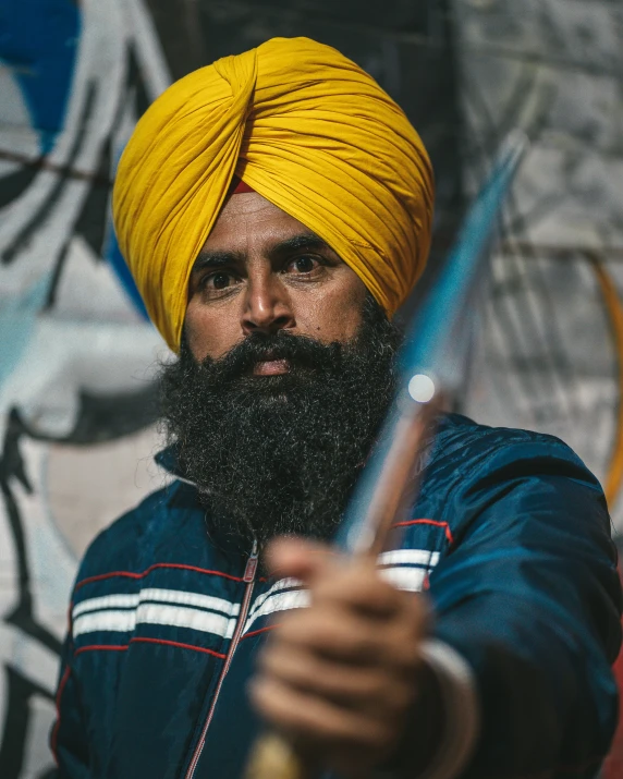 a man with a yellow turban holding a sword