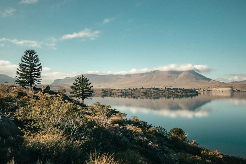 lake in the middle of a desert with mountains and clouds