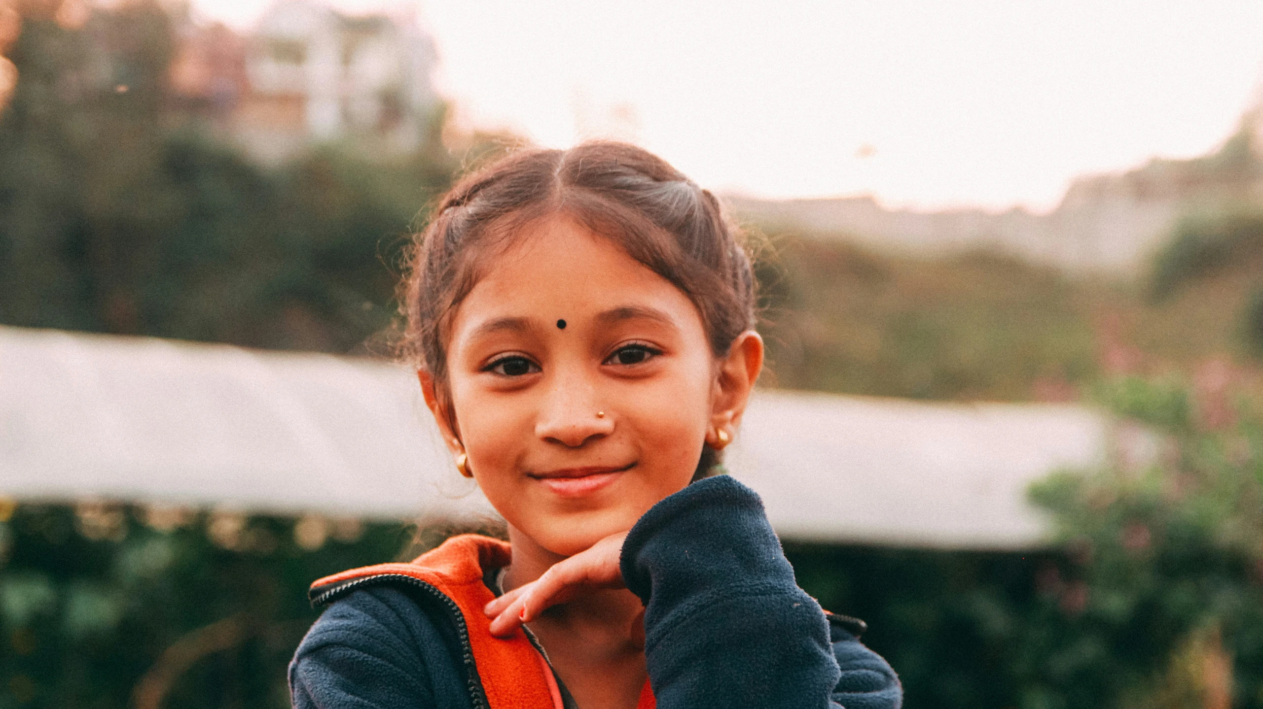 a small child posing for the camera while wearing a hoodie