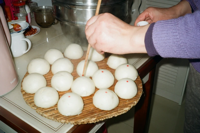 a person placing dumplings in an asian restaurant