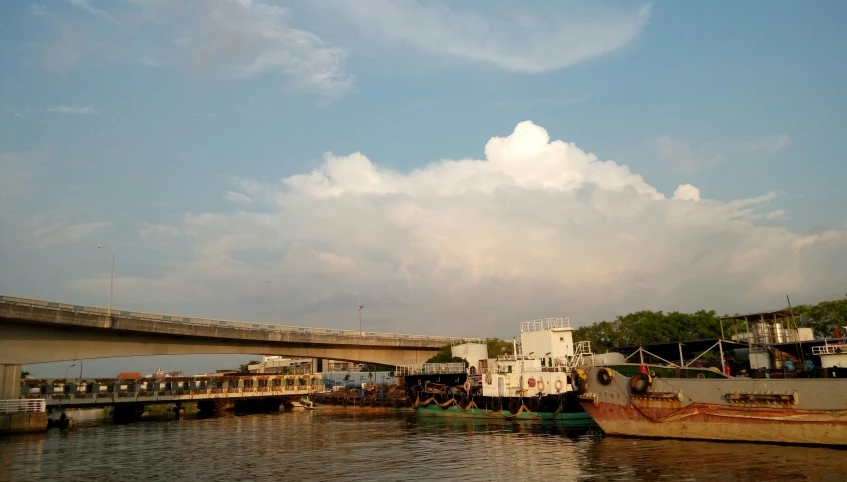 two boats docked in a harbor under a bridge