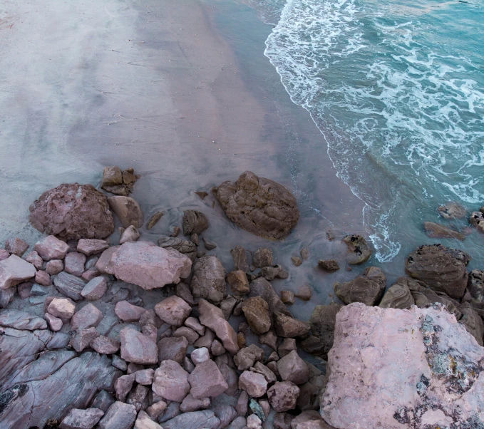 a rock beach is next to some water