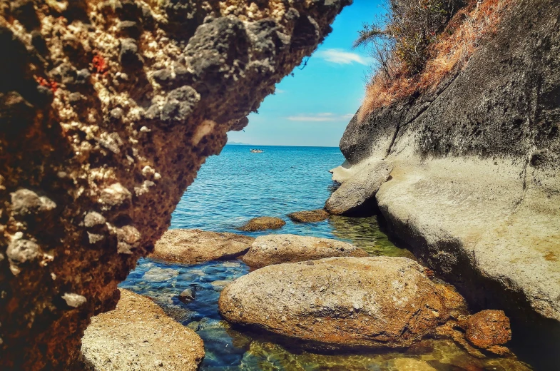 the rocks are along the water and some green moss