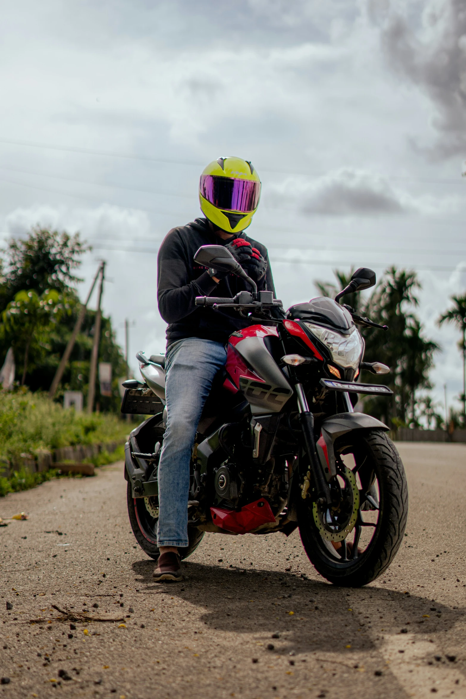 a person riding a red and black motorcycle down a road