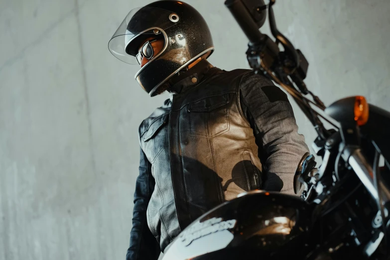 man in leather jacket and helmet on motorcycle