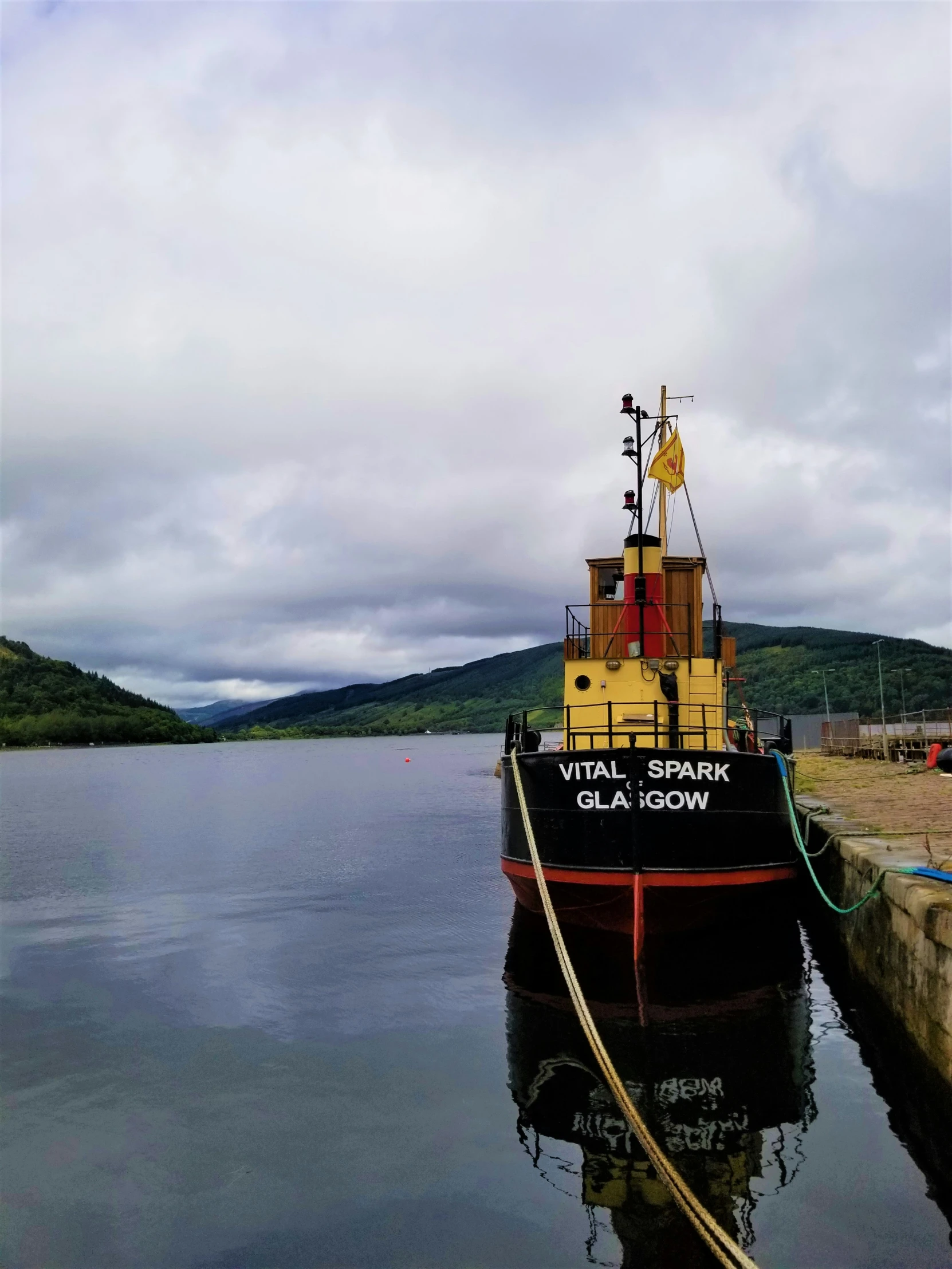 a tug boat tied to a dock with a rope on the side