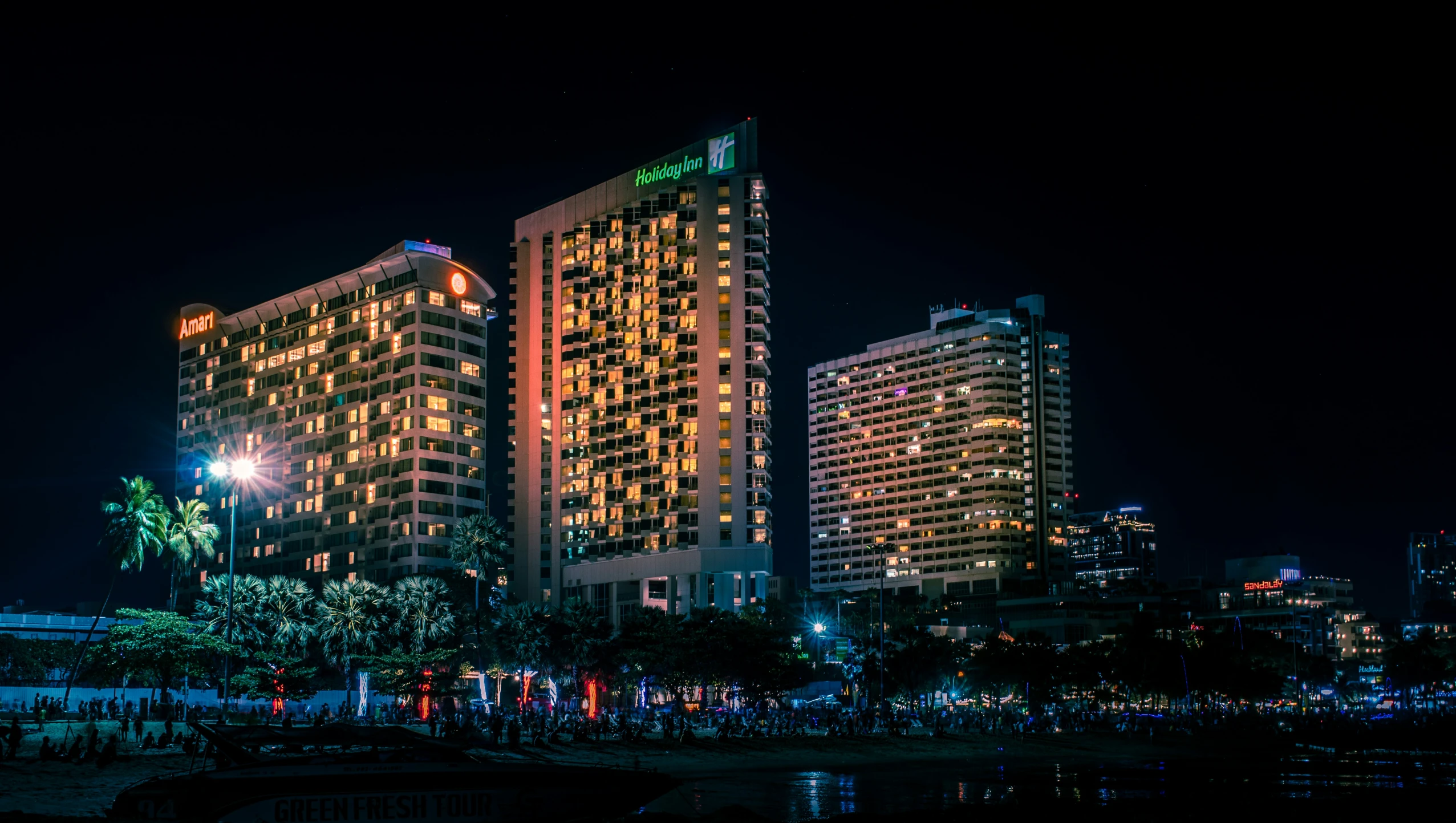 two tall buildings and a small lake in a city