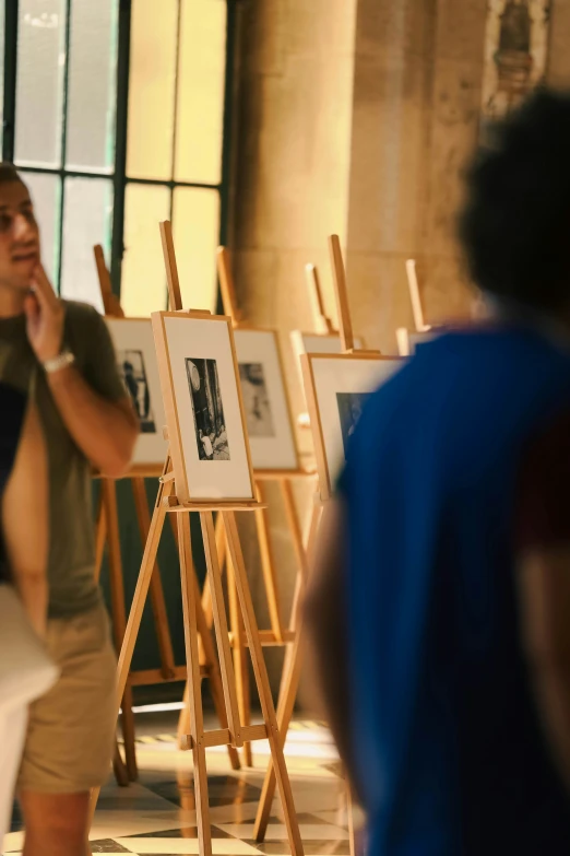 a man standing next to an easel of pictures
