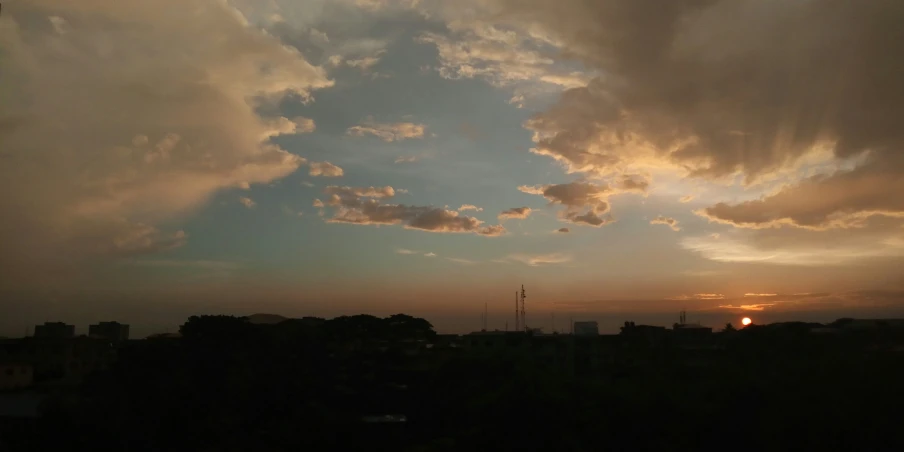 clouds in the sky above a city at sunset