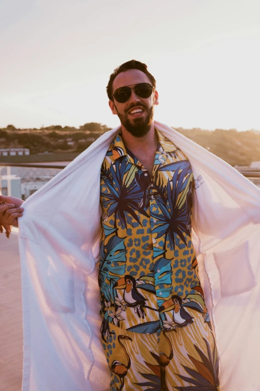 a man wearing an exotic print beach suit and sunglasses