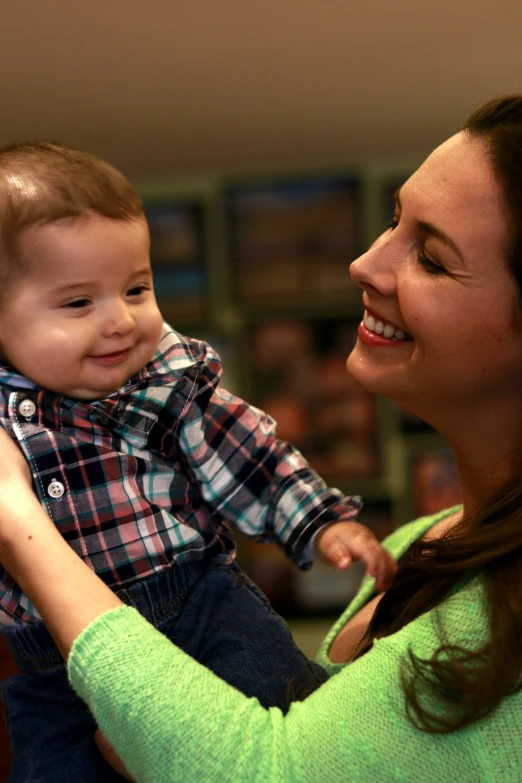 a woman smiles at her child as he holds him