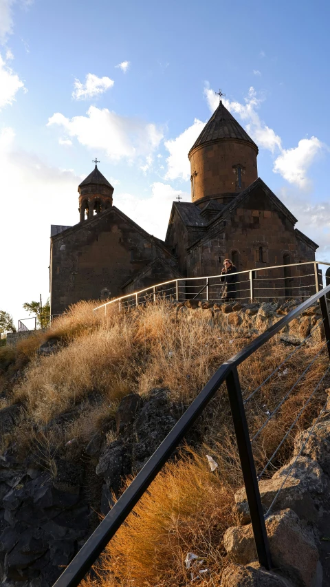 a church with three steeple stands on top of a hill