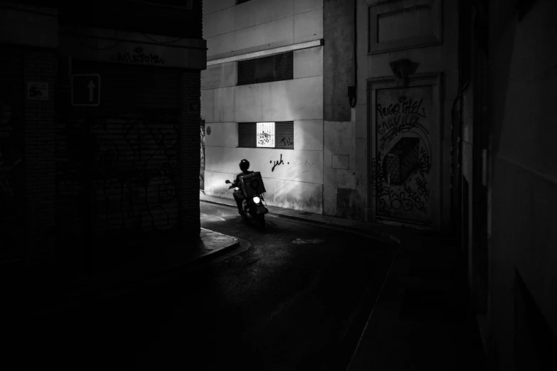 a person riding a motorcycle down a street at night