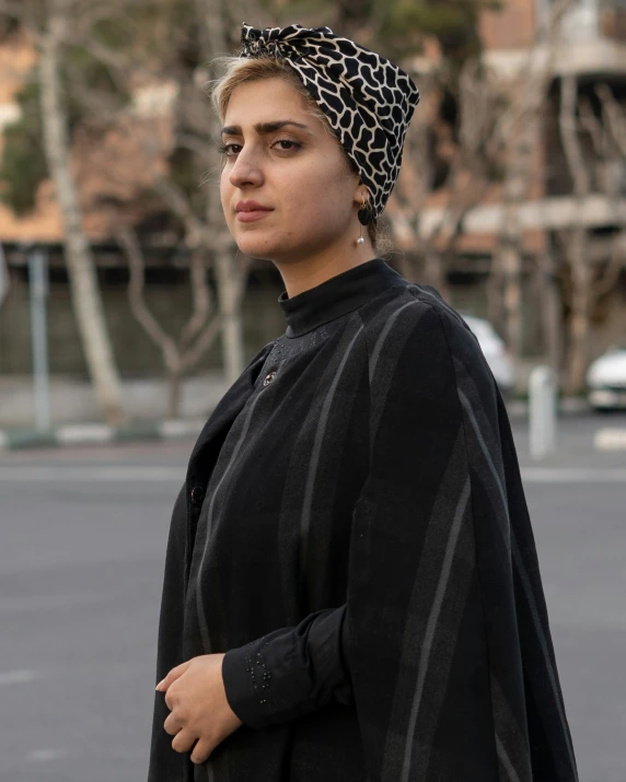 a woman wearing a black and white headwrad and a leopard print hat