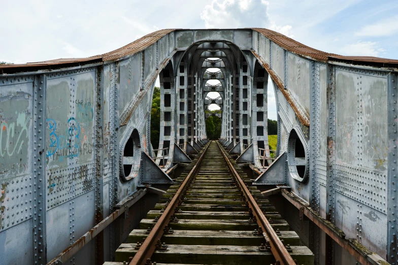 an old railway bridge with metal tracks going over the top