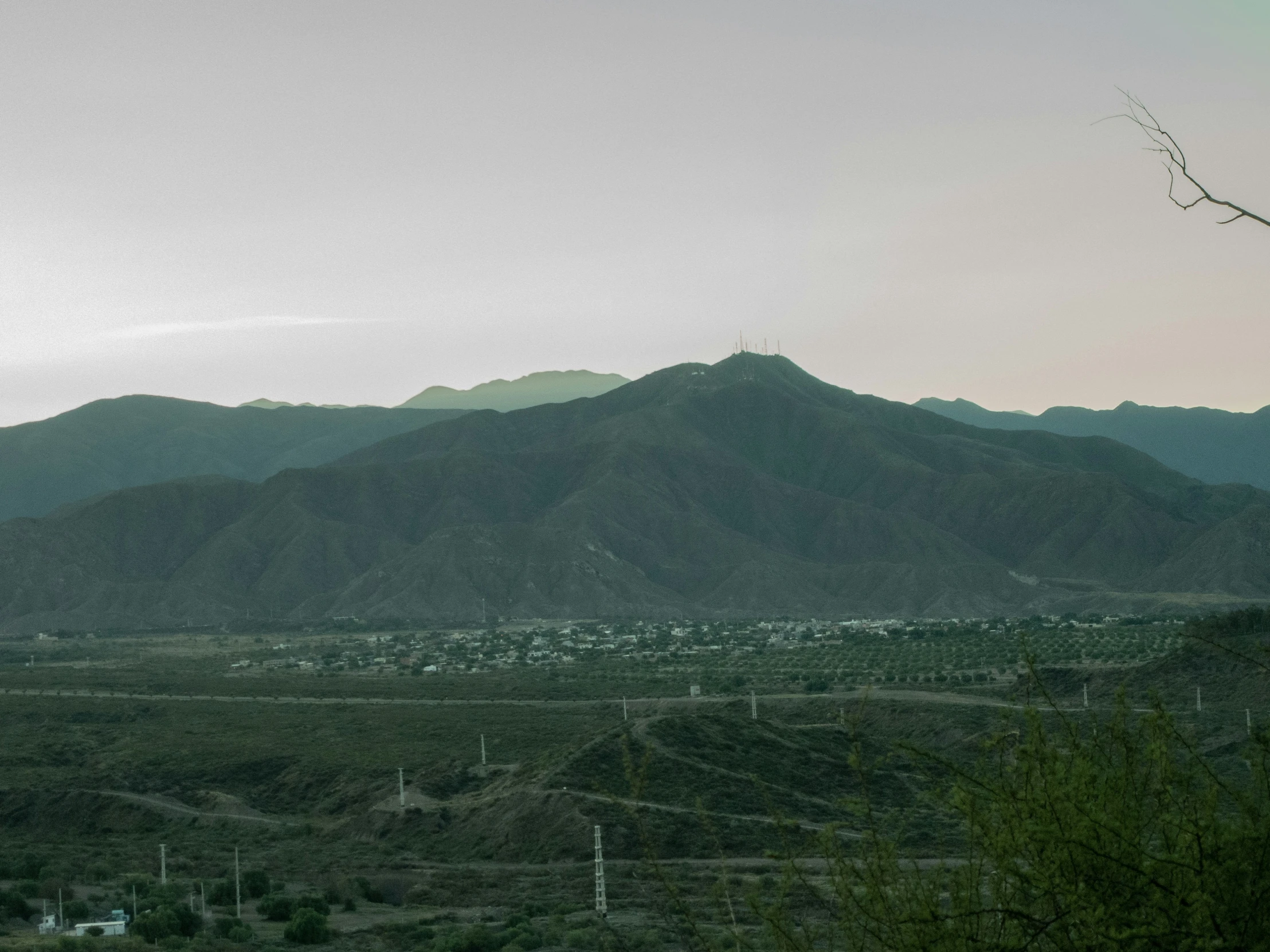 the sky is gray and overcast with a mountain range