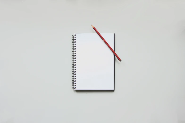 a notepad and a pencil on top of a white surface