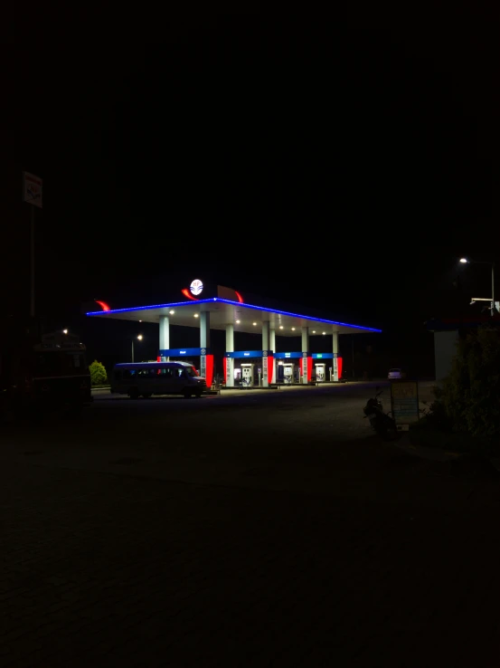 gas station with a blue, white and red light at night