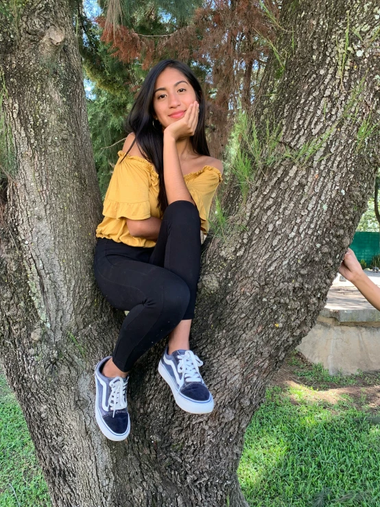 a girl in the tree with her hand up to her face