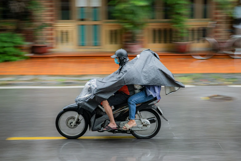 two people riding a motorcycle on the road