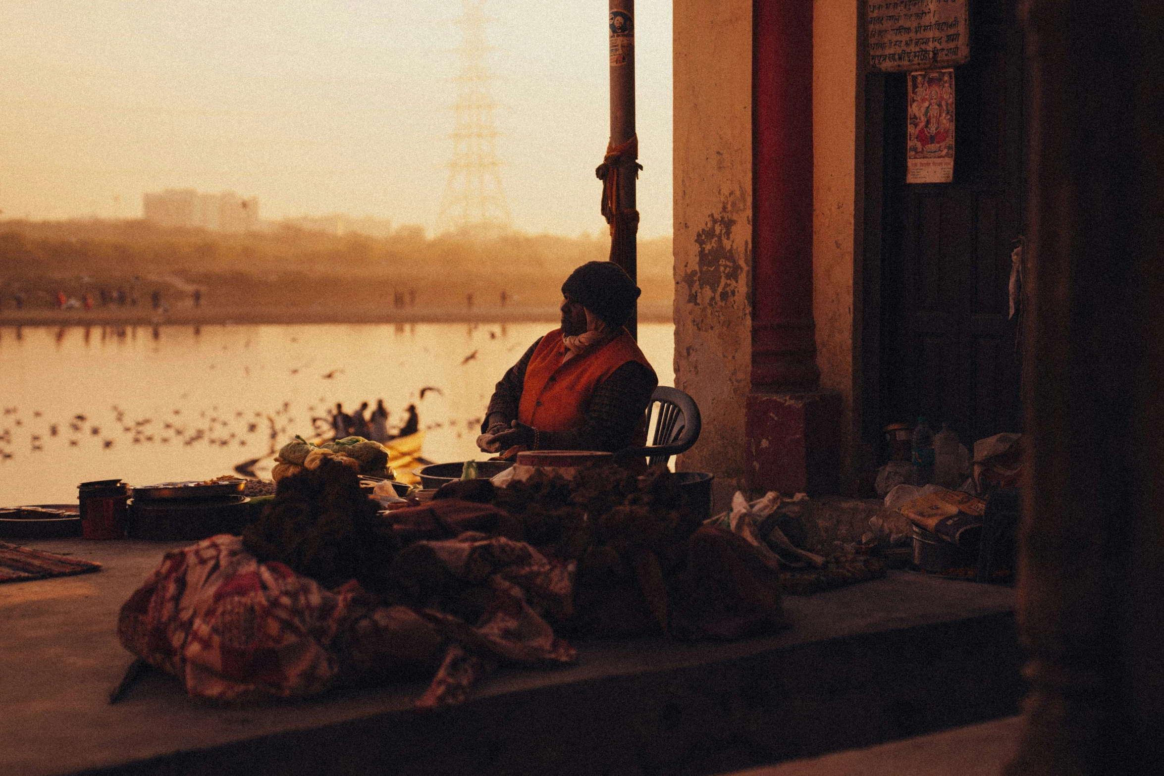 woman sitting on ledge in front of a lake surrounded by boxes