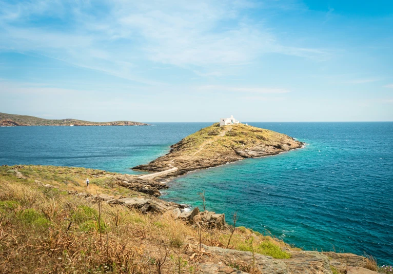 a small island sits on a beach next to the ocean