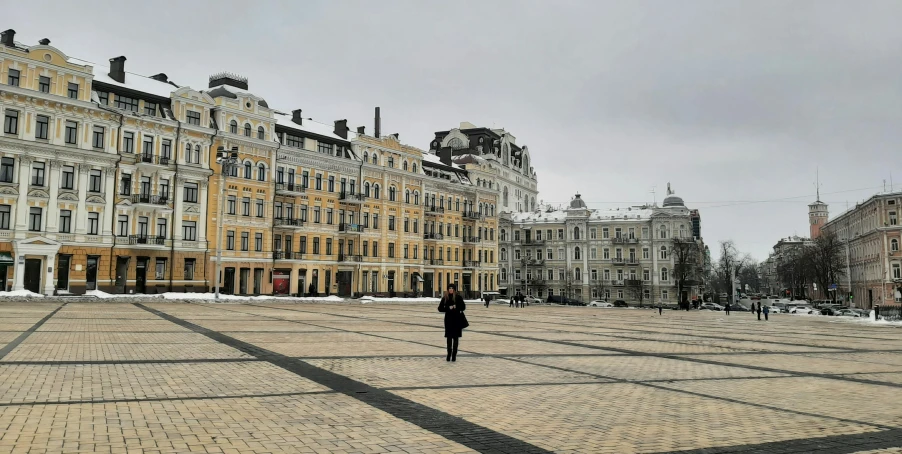 a person walking away from some large buildings